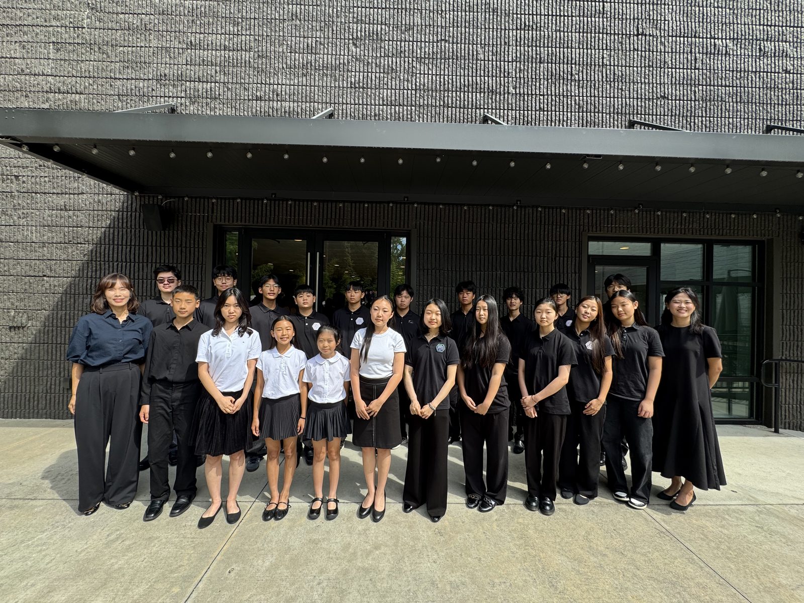 GYCO students, teachers, and their conductor gathered outside Joynus Daycare before the invited performance