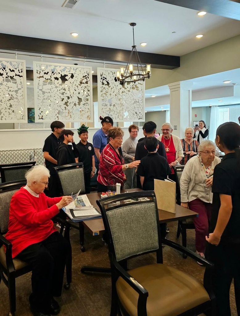 Students and senior living residents visiting together after a holiday performance