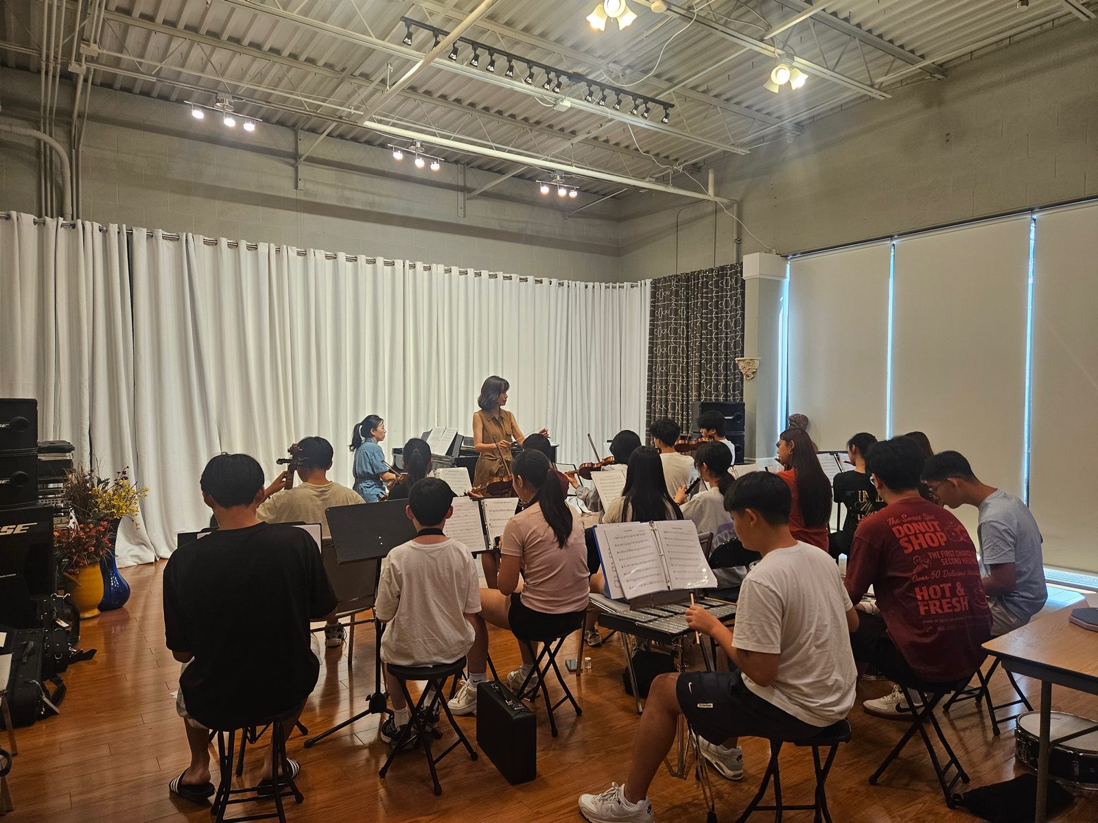 The full GYCO ensemble rehearsing with their conductor and pianist in the studio