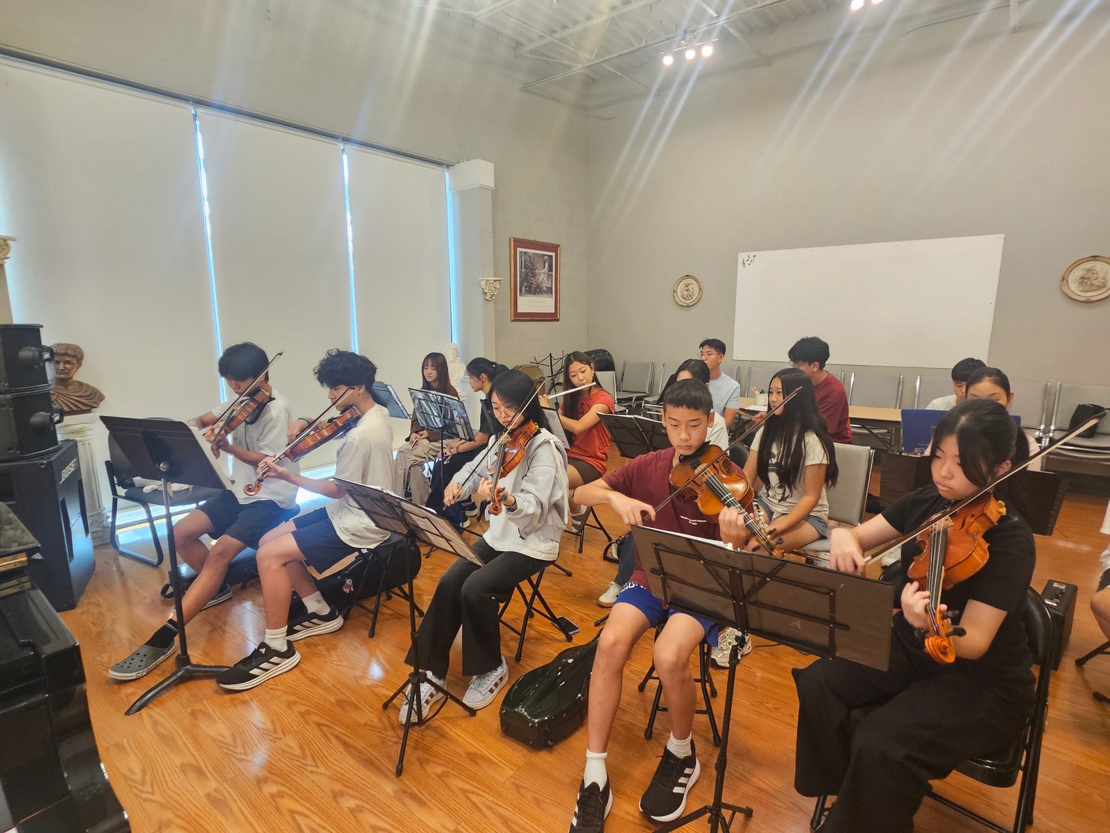 Young violinists and violists reading from their stands during a GYCO rehearsal