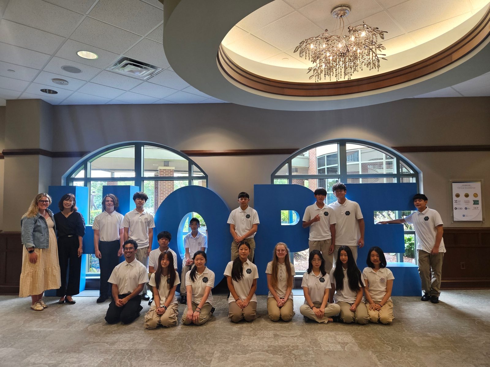 GYCO students gathered around the large blue HOPE letters at City of Hope Atlanta after their performance